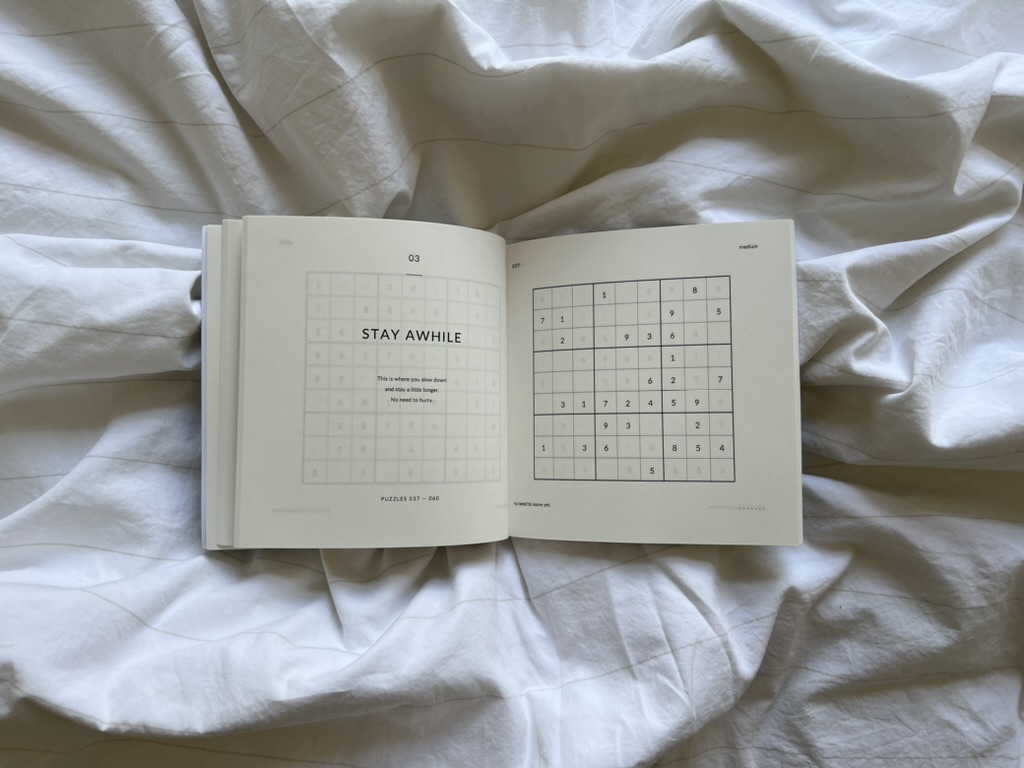 Open Nothing Urgent book showing the Stay Awhile section and a Sudoku puzzle